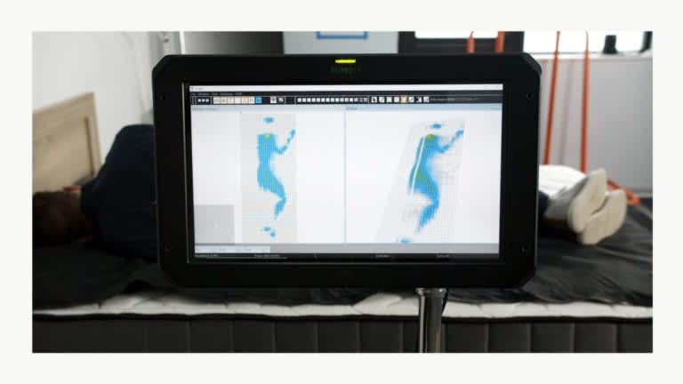Sleep Foundation tester undergoing side-sleeping pressure mapping on the Brooklyn Bedding Titan mattress