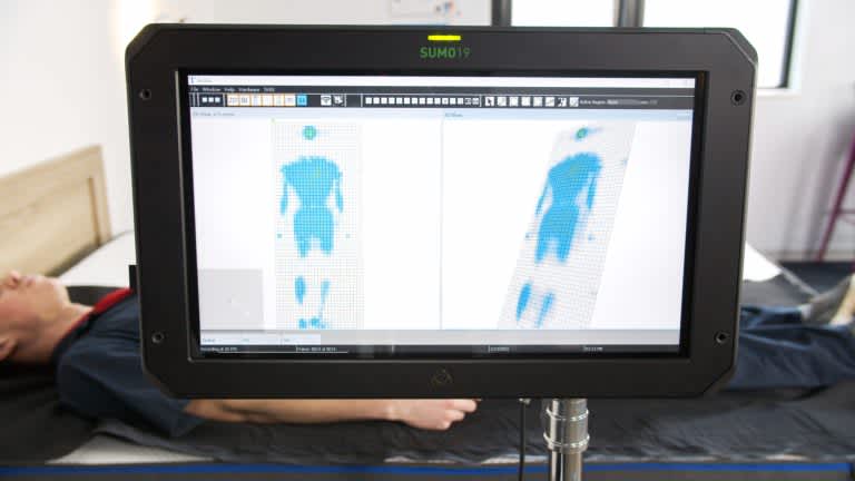 Sleep Foundation tester undergoing back-sleeping pressure mapping on a Nectar mattress