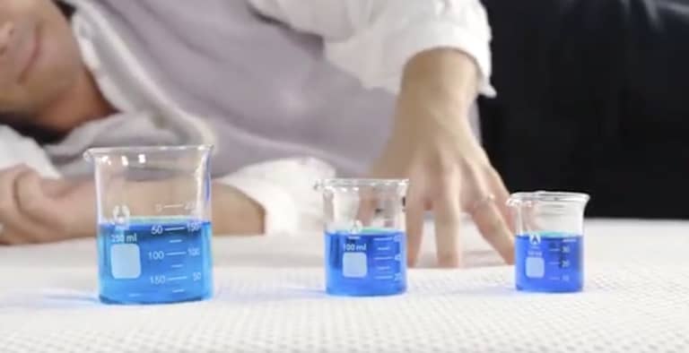 Beakers of blue liquid used during Sleep Foundation mattress motion isolation testing