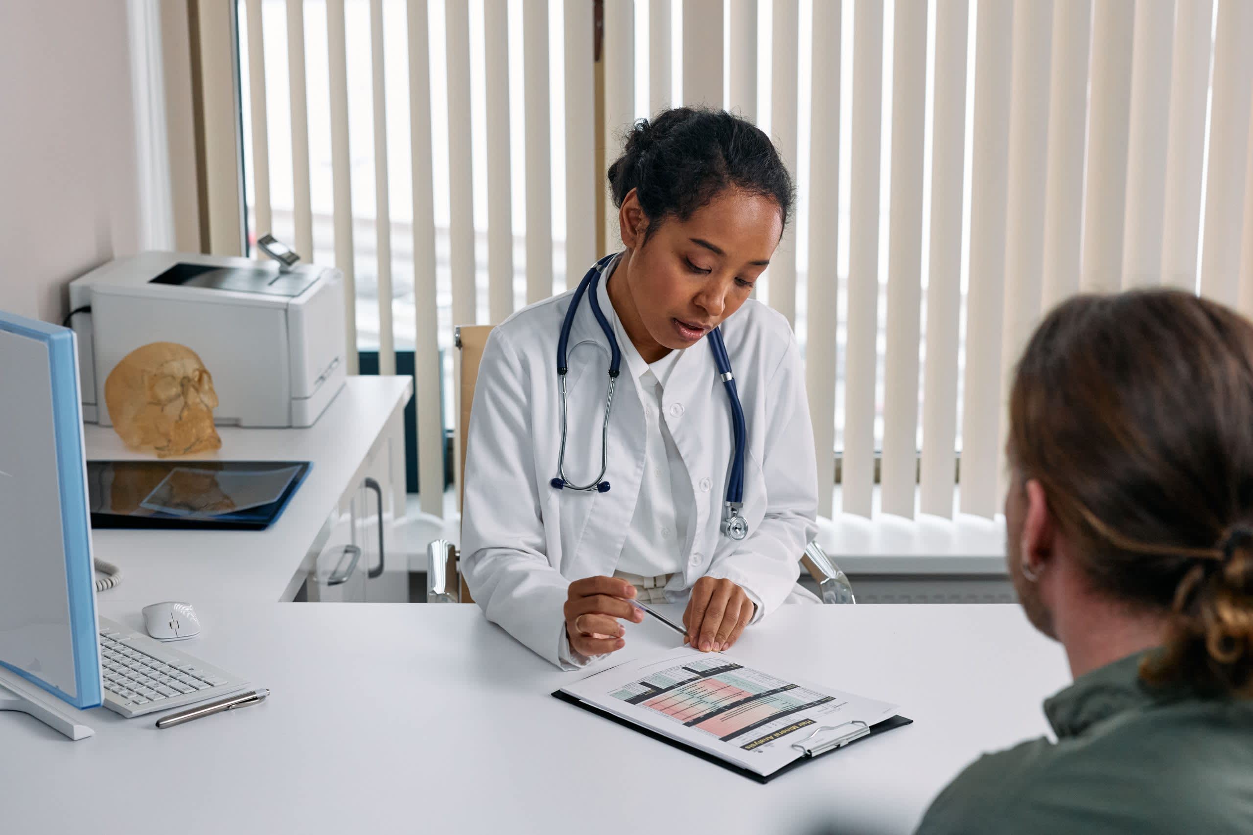 Sleep Apnea Surgery A doctor consulting with a patient in an office, discussing a medical chart.