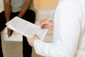 STOP-Bang Score Healthcare professional reviews medical form during patient consultation in a clinic setting