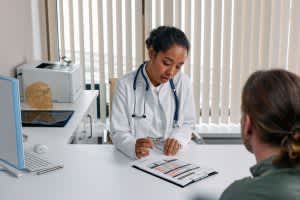 Sleep Apnea Surgery A doctor consulting with a patient in an office, discussing a medical chart.