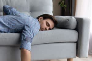 product image of a man sleeping on a couch