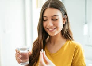 Healthy young woman taking supplements
